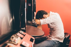 man on slot machine considers lies gamblers tell at gamblers rehab