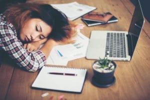 A woman is slumped in front of her laptop and notes while she is coming down from cocaine