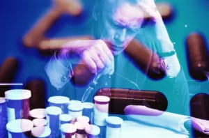 A man stares at a bunch of pill bottles trying to understand the difference between oxycontin and oxycodone