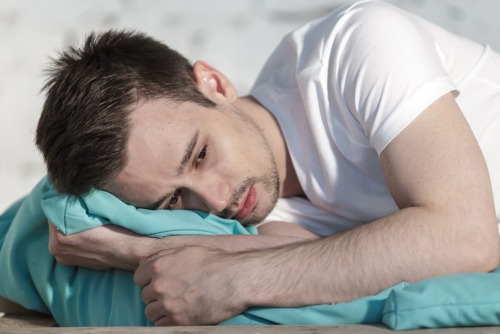 pensive man lying down in bed, benzo withdrawal timeline