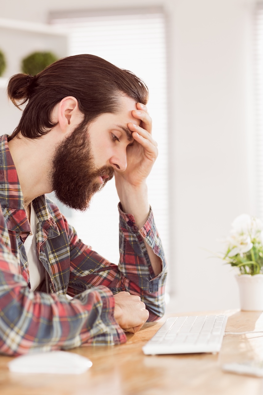 Rustic businessman stressed at desk in an office