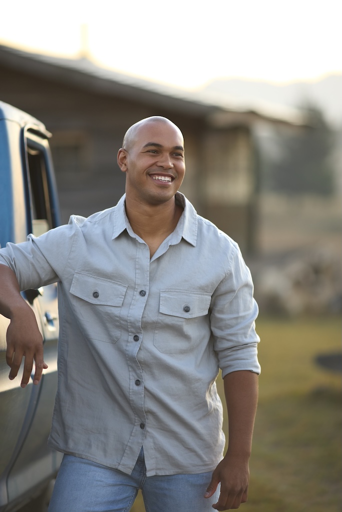 Portrait Of Man With Pick Up Truck Near Cabin in Countryside