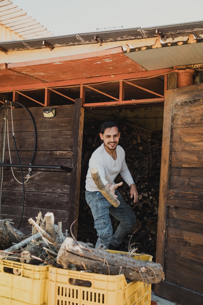 young man arranges wood in boxes.