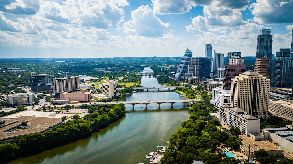 An aerial view of downtown Austin with modern buildings along the riverbank. Texas, USA