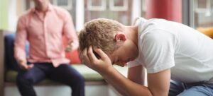 Parent scolding young adult male who is struggling with mental health and substance use issues