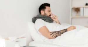 Sick guy in withdrawal, lying under blanket in bed