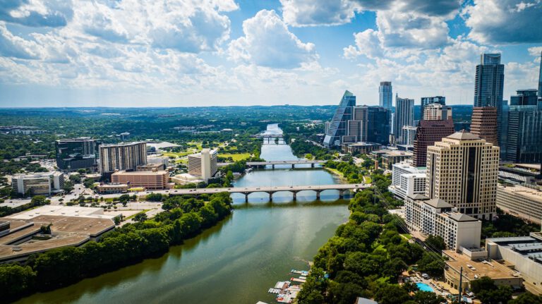 An aerial view of downtown Austin with modern buildings along the riverbank. Texas, USA