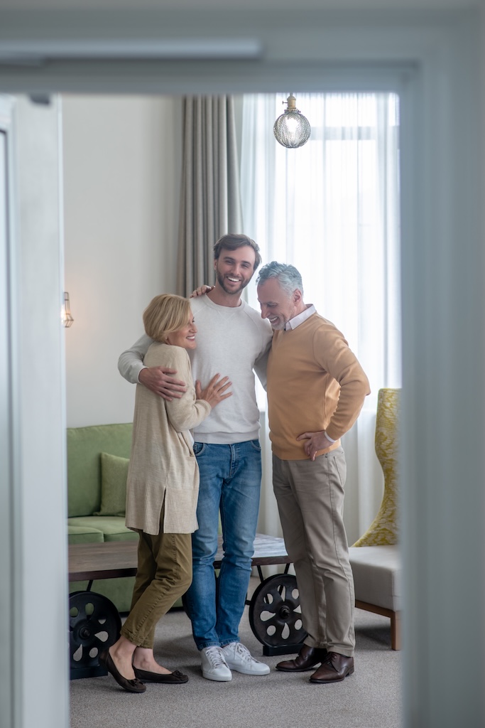 Family together with young adult son feeling happy and contented