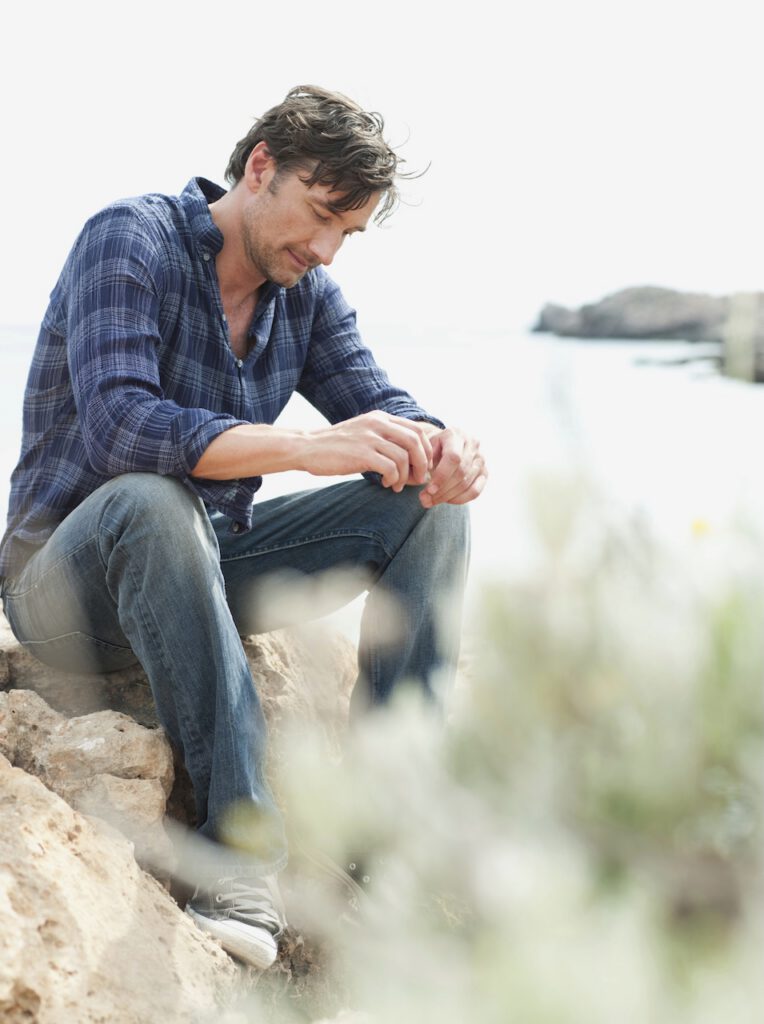 Man sitting on rock at cliffs