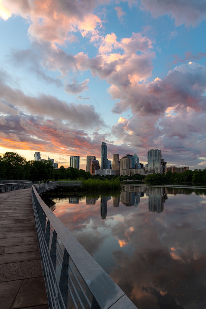 A vertical shot of TX skyline at sunset from the boardwalk along Town Lake in Austin city, which is where our inpatient rehab is located.