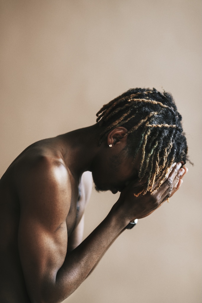 Black man posing by a beige background