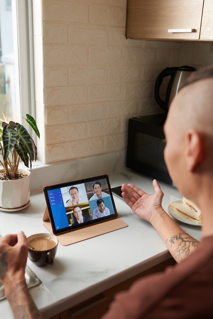 Man driking morning coffee when having online meeting for mental health and substance use virtual outpatient treatment program.